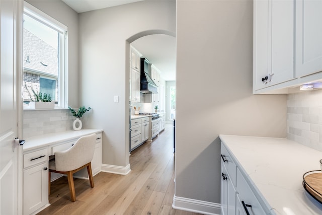 home office featuring built in desk and light hardwood / wood-style flooring