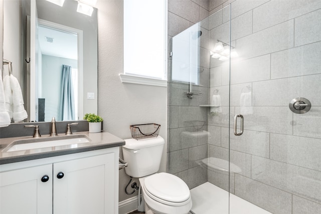 bathroom featuring vanity, toilet, and walk in shower