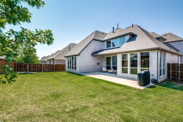 back of property with a patio area and a yard