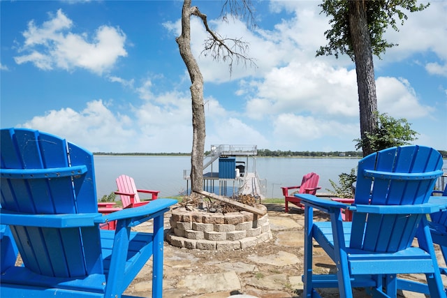 view of patio / terrace with a fire pit and a water view