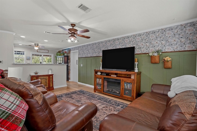 living room with light wood-type flooring and crown molding