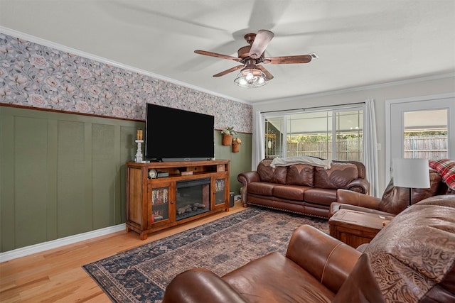 living room featuring ceiling fan, wood-type flooring, and ornamental molding