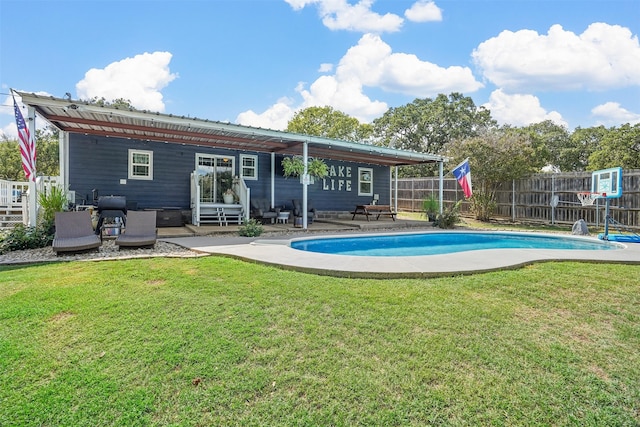 back of property featuring a fenced in pool, a yard, and a patio