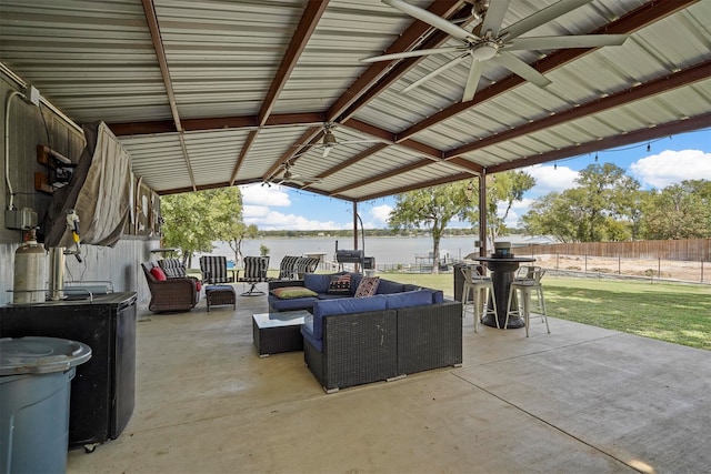 view of patio / terrace with a gazebo, ceiling fan, a water view, and an outdoor living space