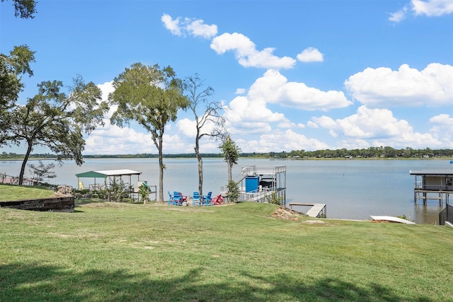 view of dock with a water view and a lawn