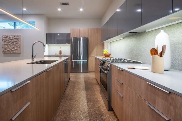 kitchen featuring appliances with stainless steel finishes, hanging light fixtures, sink, and decorative backsplash