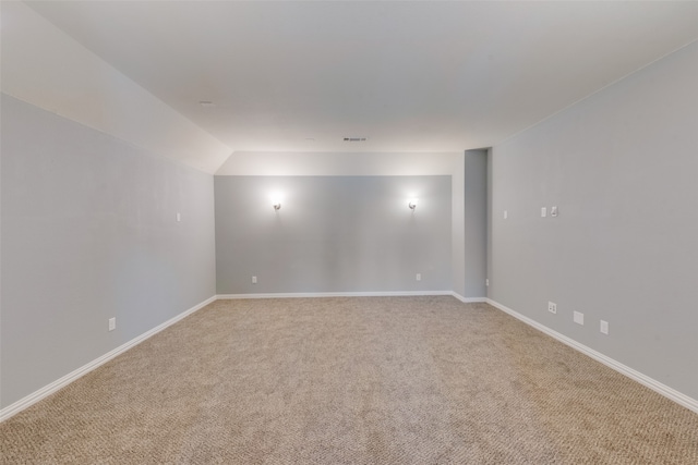 empty room with light carpet and vaulted ceiling