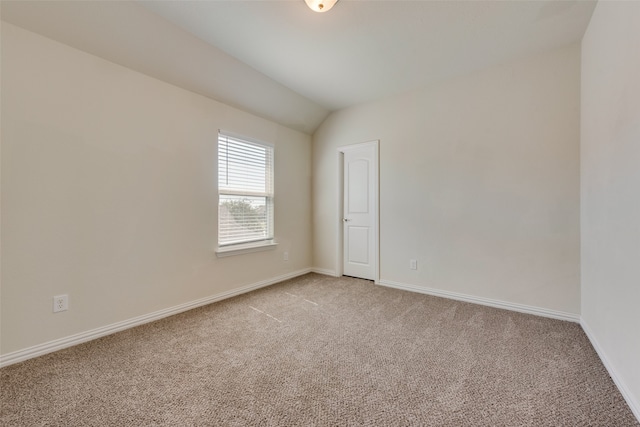 carpeted spare room with lofted ceiling