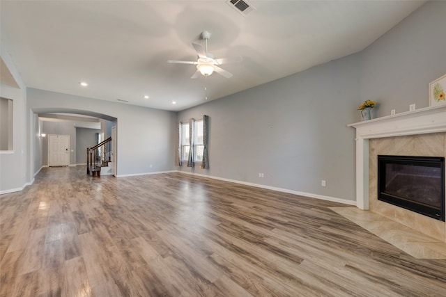 unfurnished living room featuring a high end fireplace, light hardwood / wood-style floors, and ceiling fan