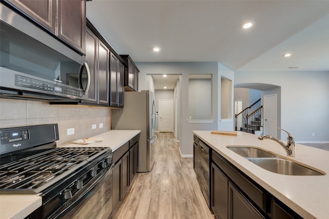 kitchen with black appliances, decorative backsplash, light wood-type flooring, dark brown cabinets, and sink