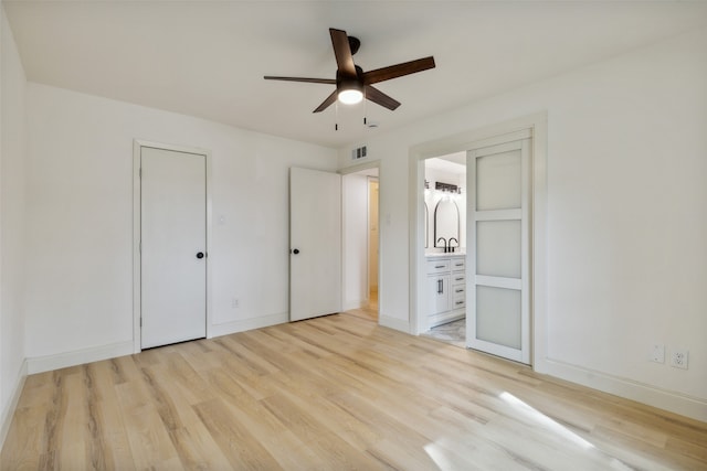 unfurnished bedroom featuring ceiling fan, light hardwood / wood-style flooring, and connected bathroom