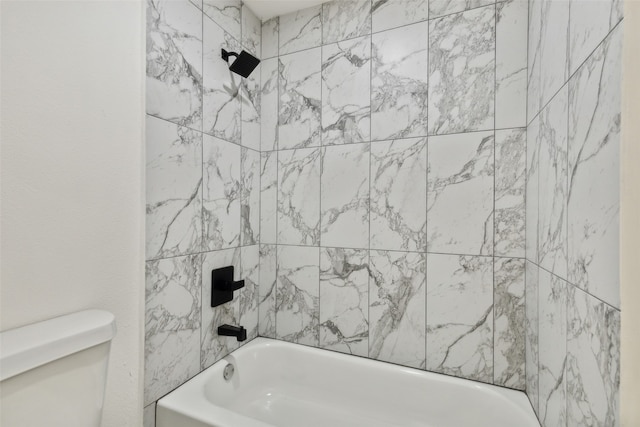 bathroom featuring tiled shower / bath and toilet