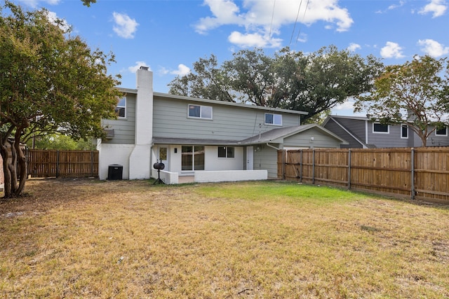 back of property featuring a lawn and central air condition unit