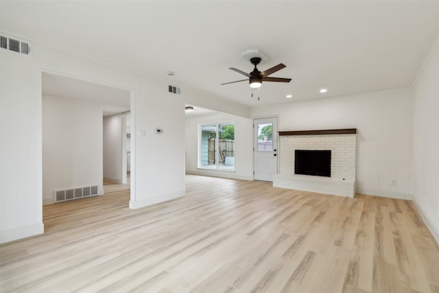 unfurnished living room featuring ceiling fan, a fireplace, and light hardwood / wood-style flooring