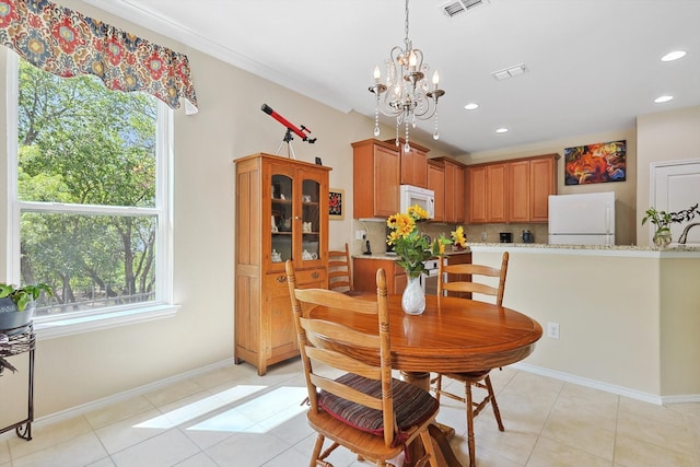 tiled dining room featuring an inviting chandelier and crown molding