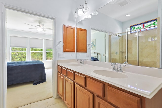 bathroom with ceiling fan, vanity, a shower with shower door, and tile patterned flooring