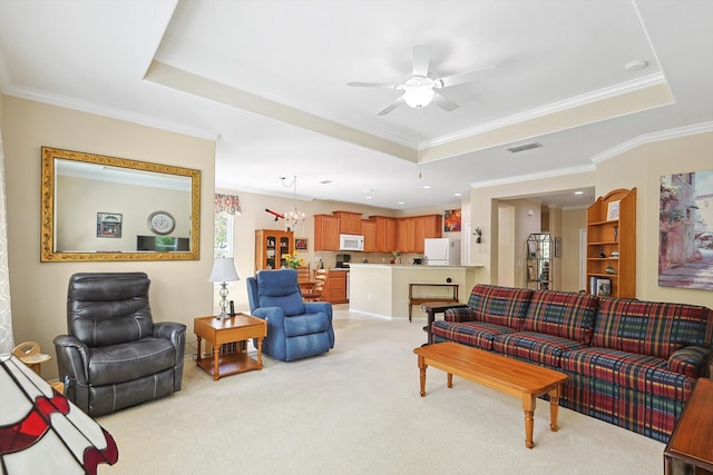 living room with ceiling fan with notable chandelier, ornamental molding, light carpet, and a raised ceiling