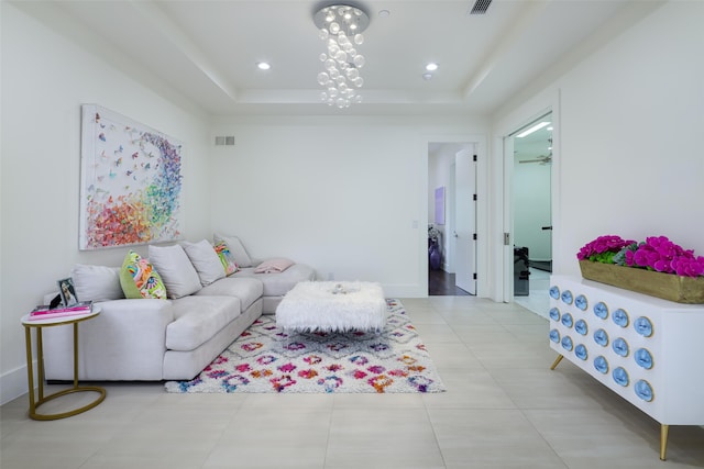 living room featuring ceiling fan and a tray ceiling