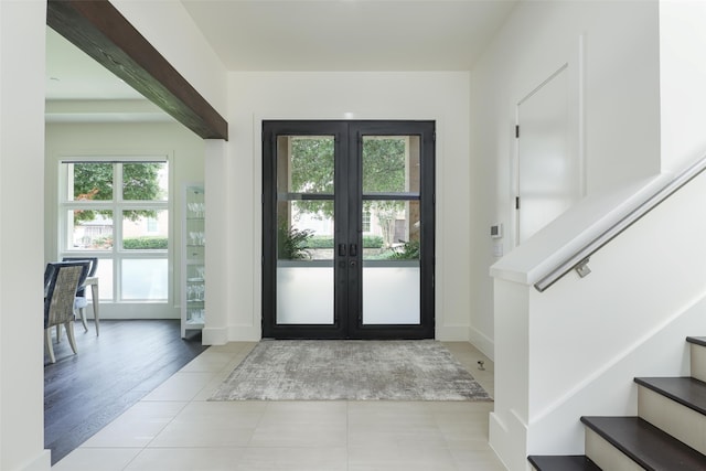 entryway with light tile patterned floors and french doors