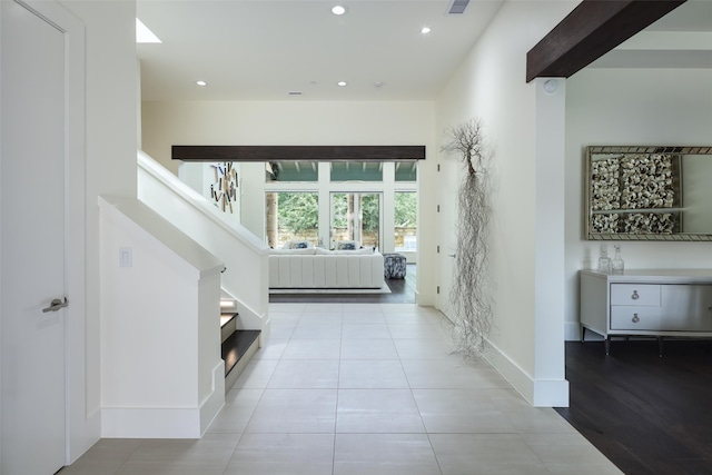 hallway featuring light tile patterned floors and a towering ceiling