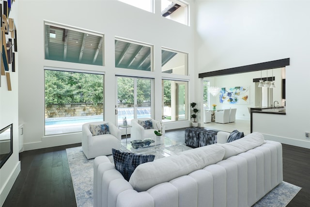 living room featuring dark hardwood / wood-style floors, a wealth of natural light, and a high ceiling