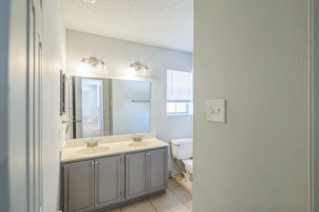 bathroom featuring vanity, toilet, a textured ceiling, and tile patterned flooring