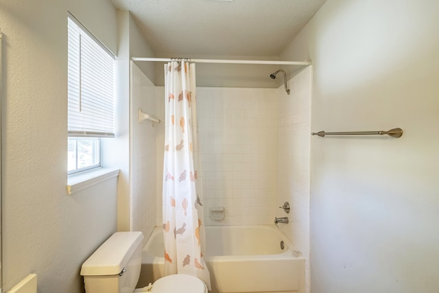 bathroom featuring shower / bath combo, a textured ceiling, and toilet