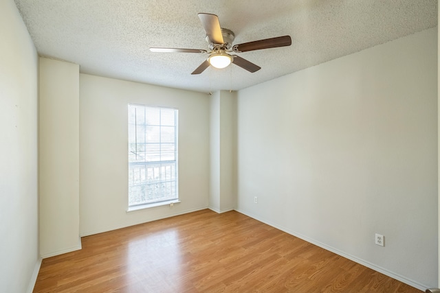 empty room with light hardwood / wood-style floors, a textured ceiling, and ceiling fan