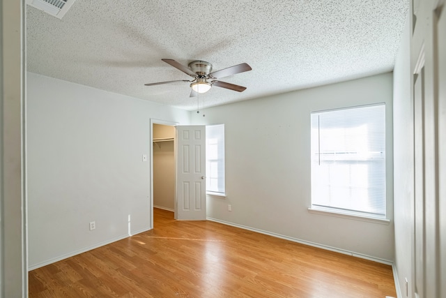 spare room with light hardwood / wood-style floors, a textured ceiling, and ceiling fan