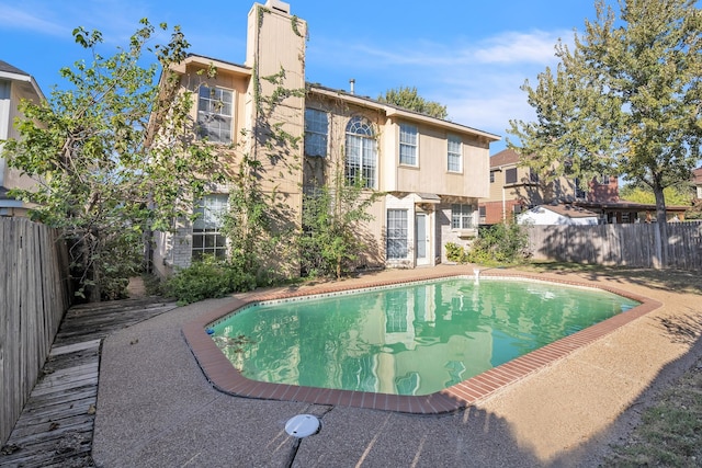 back of house featuring a fenced in pool