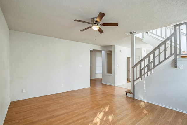 unfurnished living room featuring light hardwood / wood-style floors, a textured ceiling, and ceiling fan