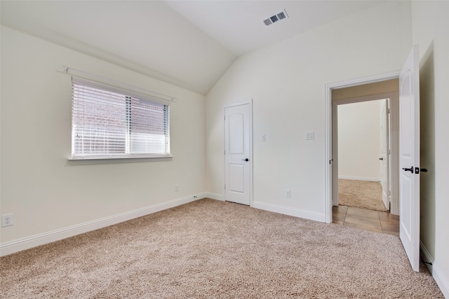 unfurnished bedroom featuring lofted ceiling and light carpet