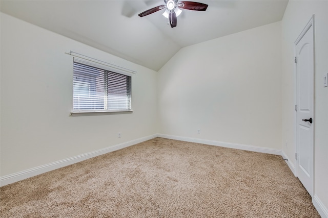 carpeted spare room with ceiling fan and vaulted ceiling