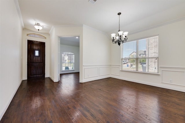 entrance foyer with ornamental molding, a notable chandelier, and dark hardwood / wood-style flooring