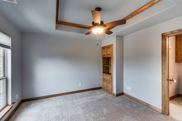 interior space with ceiling fan and a raised ceiling