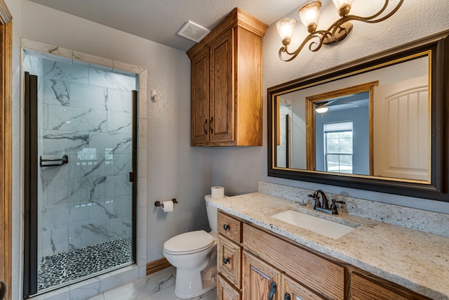 bathroom with vanity, a textured ceiling, a shower with door, toilet, and a notable chandelier