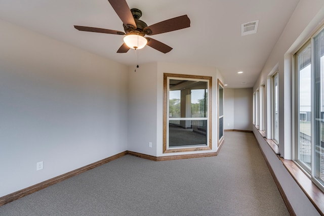 carpeted spare room with ceiling fan and a healthy amount of sunlight