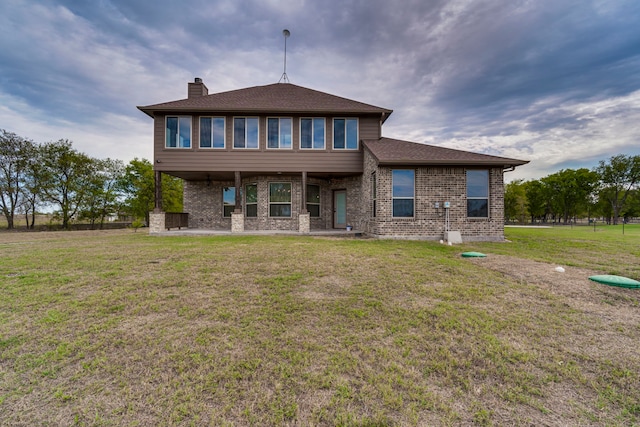 rear view of property featuring a yard