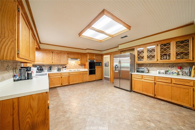 kitchen featuring light tile patterned flooring, stainless steel appliances, backsplash, and ornamental molding