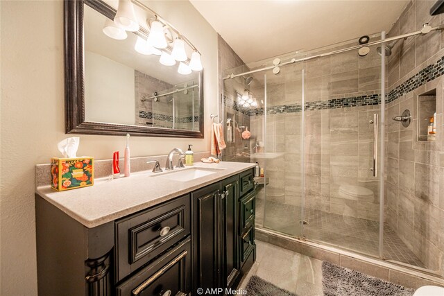 bathroom featuring vanity and a shower with shower door