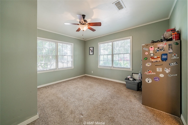 interior space featuring a healthy amount of sunlight, ornamental molding, ceiling fan, and light colored carpet