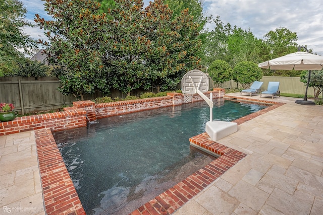 view of swimming pool with a storage unit, pool water feature, and a patio area