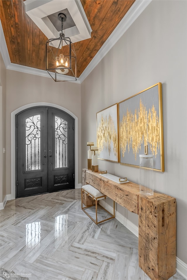 foyer with wood ceiling, light parquet floors, an inviting chandelier, french doors, and ornamental molding