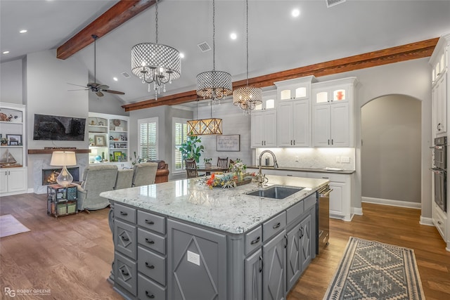 kitchen with ceiling fan with notable chandelier, white cabinets, decorative light fixtures, and sink