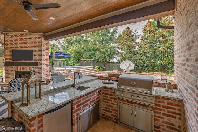 view of patio / terrace featuring ceiling fan, a grill, an outdoor kitchen, and sink