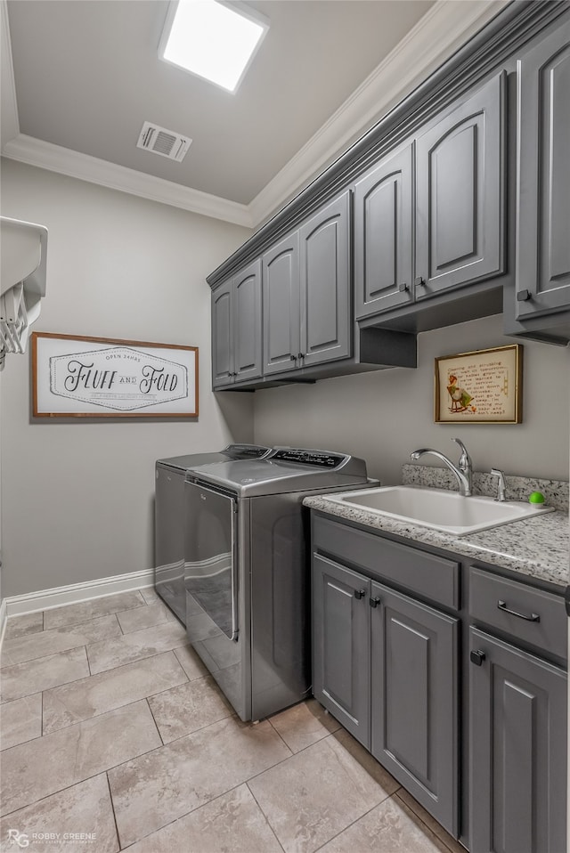 laundry area with ornamental molding, cabinets, sink, and washing machine and dryer