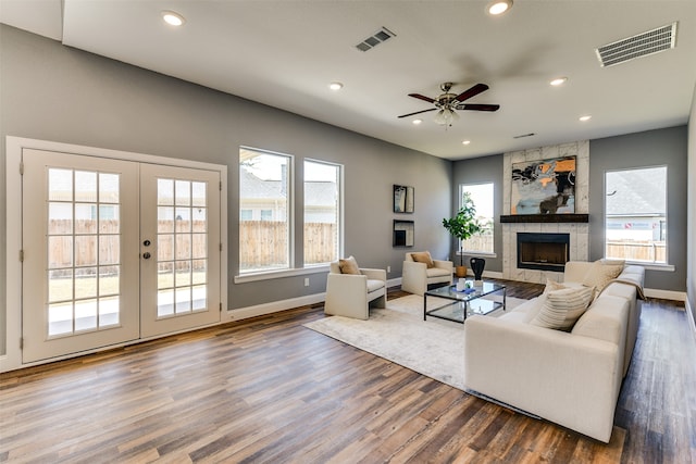 living room with french doors, hardwood / wood-style floors, ceiling fan, and a fireplace