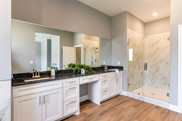 bathroom with hardwood / wood-style floors, an enclosed shower, and vanity