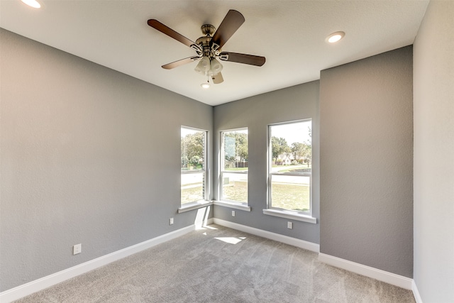 carpeted spare room with ceiling fan