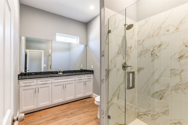 bathroom with walk in shower, vanity, toilet, and hardwood / wood-style flooring